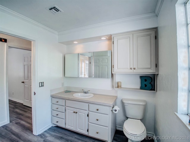 bathroom with wood-type flooring, ornamental molding, vanity, and toilet