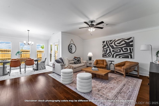living room featuring crown molding, ceiling fan with notable chandelier, lofted ceiling, dark wood-style flooring, and visible vents