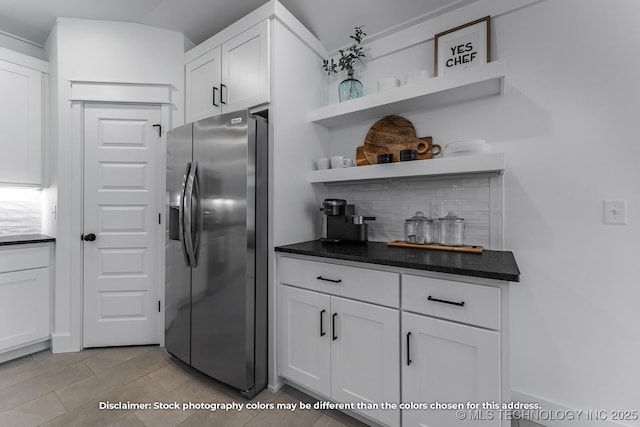 kitchen featuring white cabinets, stainless steel fridge, tasteful backsplash, dark countertops, and open shelves