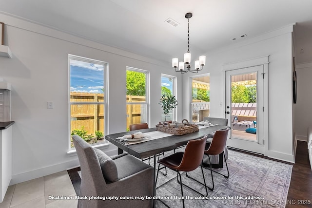 dining area with a wealth of natural light, visible vents, and a notable chandelier