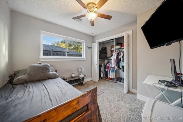 bedroom featuring a closet, ceiling fan, light carpet, and a textured ceiling