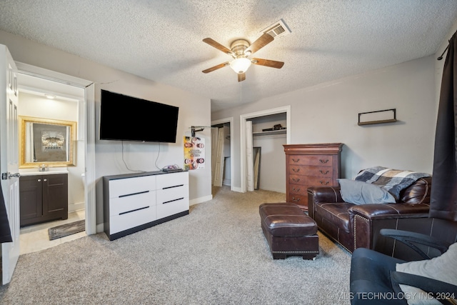 carpeted living room with a textured ceiling and ceiling fan