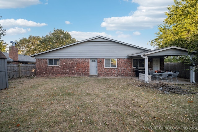 rear view of house with a patio and a lawn