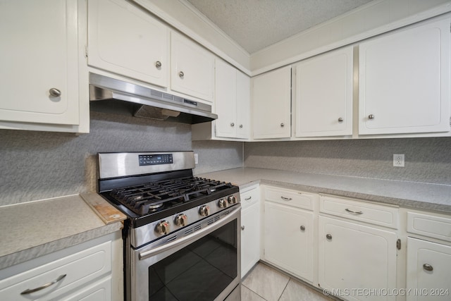 kitchen with a textured ceiling, stainless steel range with gas stovetop, white cabinetry, crown molding, and light tile patterned floors