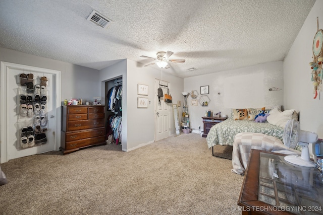 carpeted bedroom featuring a closet, ceiling fan, and a textured ceiling