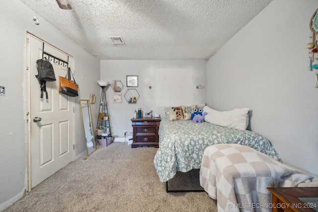 bedroom featuring ceiling fan, carpet flooring, and a textured ceiling