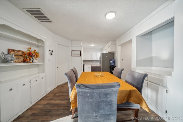 dining space featuring dark hardwood / wood-style floors and a textured ceiling