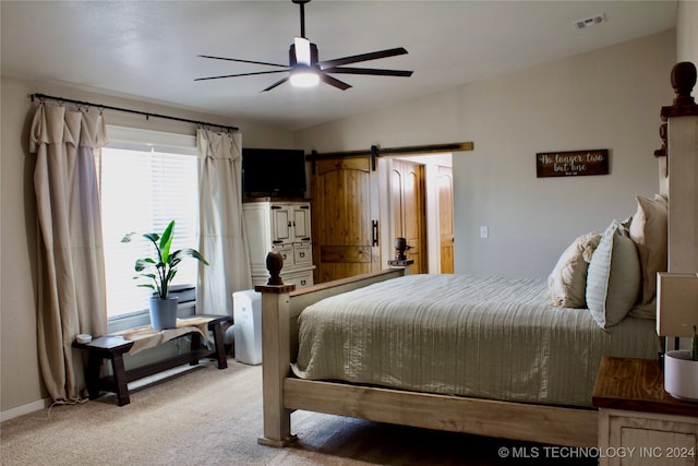 bedroom with light colored carpet, ceiling fan, vaulted ceiling, and a barn door