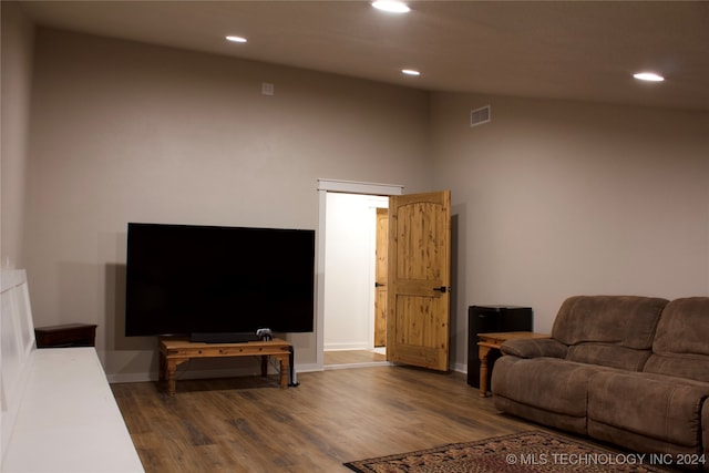 living room featuring wood-type flooring and high vaulted ceiling