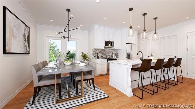 kitchen with white cabinets, an island with sink, pendant lighting, white fridge with ice dispenser, and light wood-type flooring