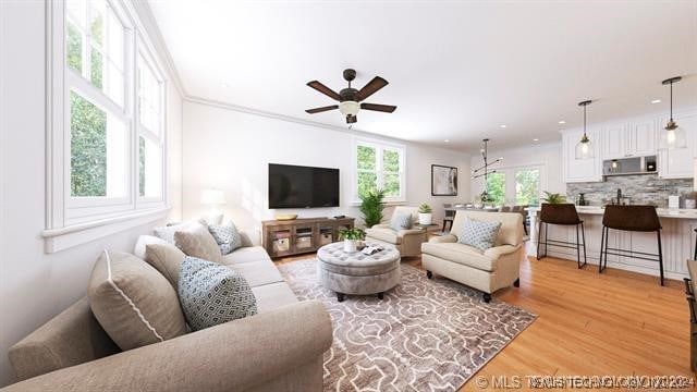 living room featuring light hardwood / wood-style floors, crown molding, and ceiling fan