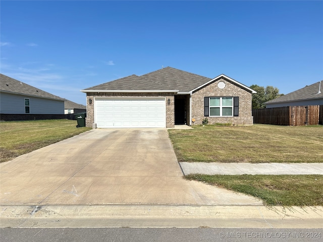 ranch-style home featuring a garage and a front lawn