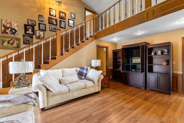 living room with hardwood / wood-style flooring and high vaulted ceiling