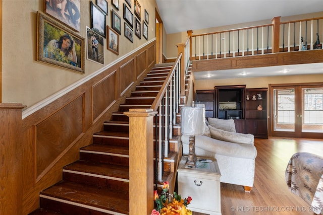 stairway featuring french doors and wood-type flooring