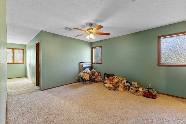 rec room featuring light carpet, a textured ceiling, and ceiling fan