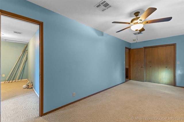 unfurnished bedroom with a closet, ceiling fan, and light colored carpet