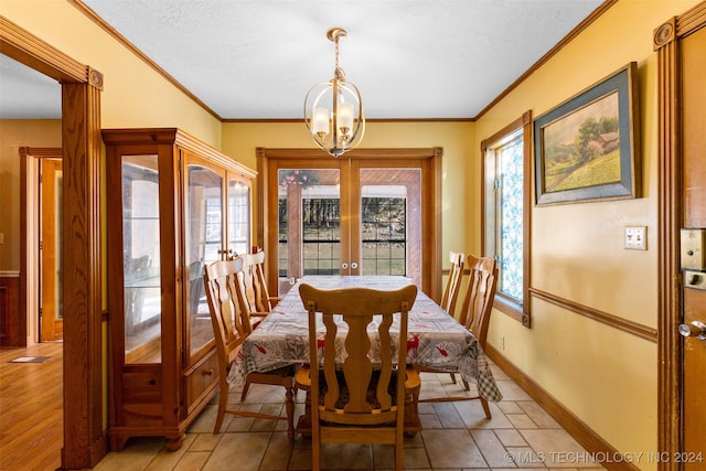 dining area with an inviting chandelier, french doors, a textured ceiling, and crown molding