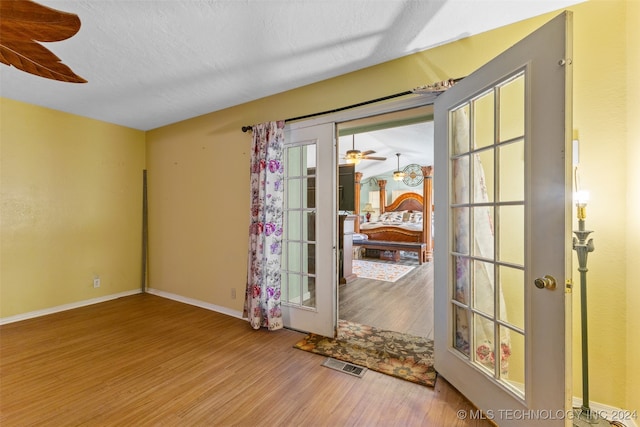 empty room featuring ceiling fan, a textured ceiling, plenty of natural light, and hardwood / wood-style floors