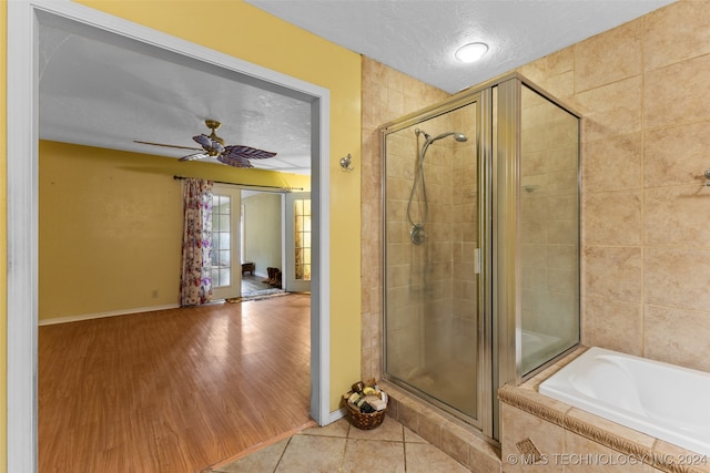 bathroom featuring hardwood / wood-style floors, shower with separate bathtub, a textured ceiling, and ceiling fan