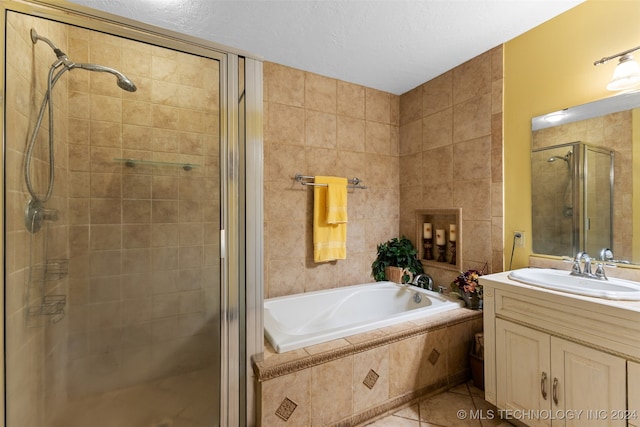 bathroom featuring vanity, a textured ceiling, plus walk in shower, and tile patterned flooring