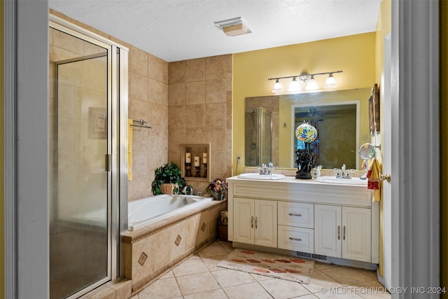 bathroom with vanity, tile patterned floors, independent shower and bath, and a textured ceiling