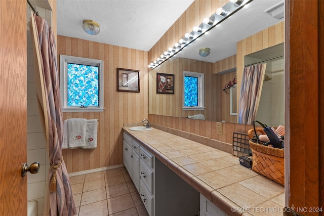 bathroom featuring vanity, a textured ceiling, tile patterned floors, and a shower with shower curtain