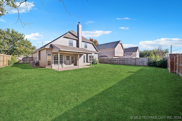 rear view of house featuring a yard, a patio, and central AC unit