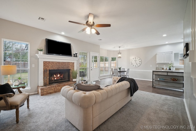 living room with ceiling fan, a fireplace, and wood-type flooring