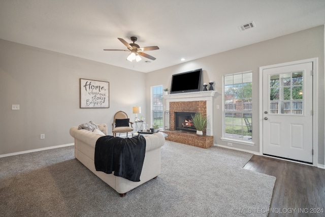 living room with ceiling fan, dark wood-type flooring, and a brick fireplace