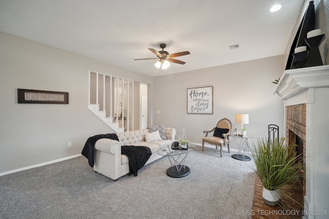 carpeted living room featuring ceiling fan and a brick fireplace