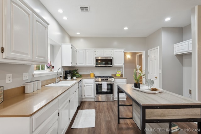 kitchen with sink, white cabinetry, stainless steel appliances, and dark wood-type flooring