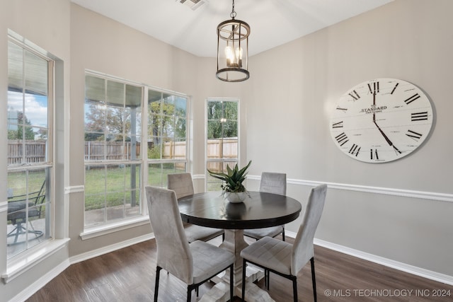 dining space with dark hardwood / wood-style floors and an inviting chandelier