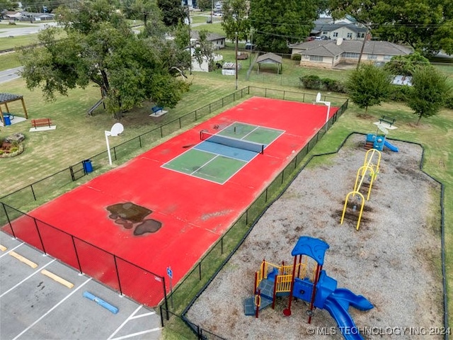 view of basketball court featuring a playground and a lawn