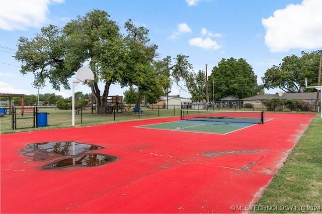 view of tennis court featuring a playground