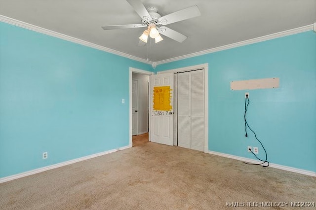 unfurnished bedroom featuring ornamental molding, light carpet, ceiling fan, and a closet