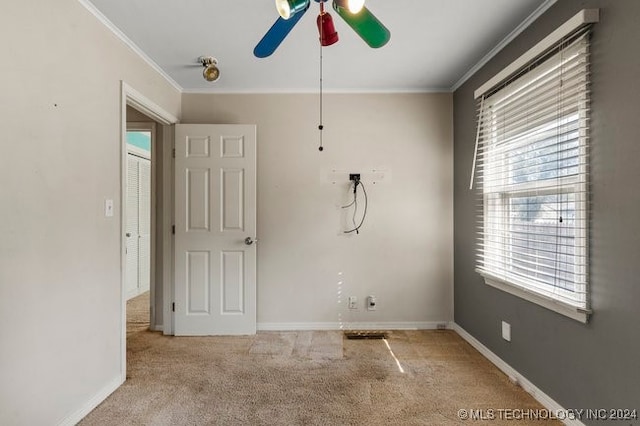 carpeted empty room with ceiling fan and crown molding