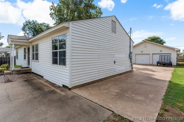 view of side of home featuring a garage and an outdoor structure