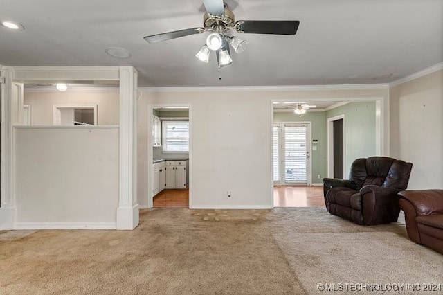 living room with crown molding, light colored carpet, and a wealth of natural light