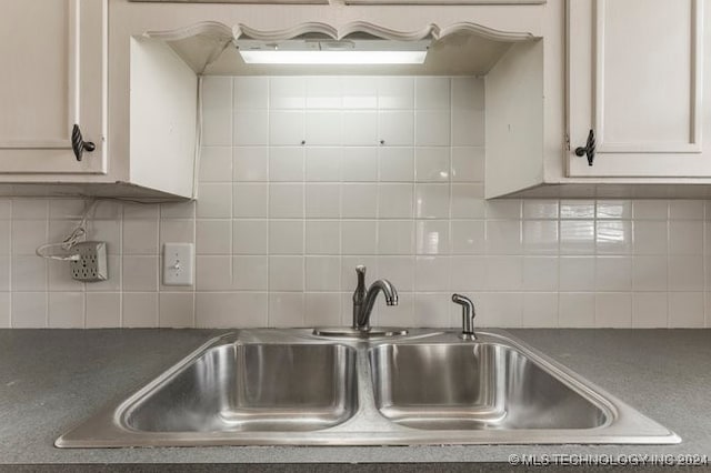 kitchen featuring sink, tasteful backsplash, and white cabinetry