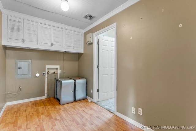 clothes washing area featuring washer hookup, electric panel, light hardwood / wood-style floors, cabinets, and crown molding