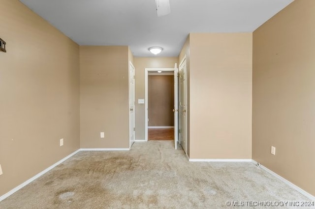 spare room with ceiling fan and light colored carpet