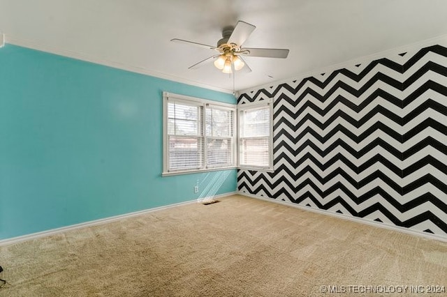 carpeted empty room with ornamental molding and ceiling fan