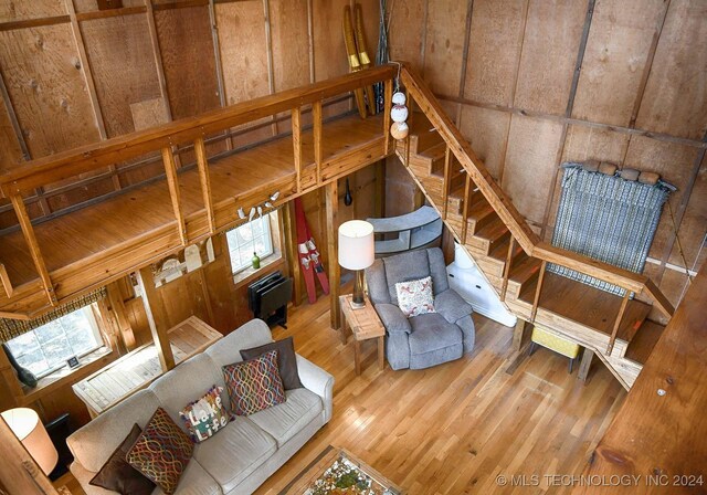 living room featuring wood-type flooring, wooden walls, and a wealth of natural light