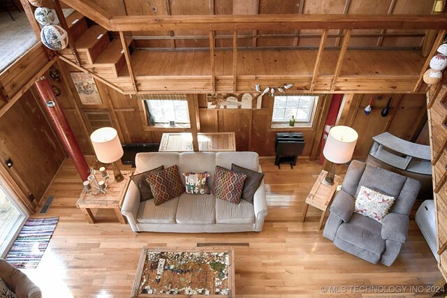 living room with wood walls and light hardwood / wood-style floors