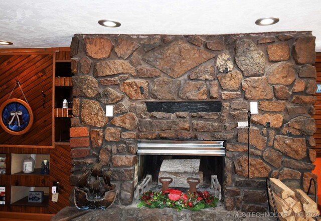 details featuring a fireplace, wood walls, and a textured ceiling