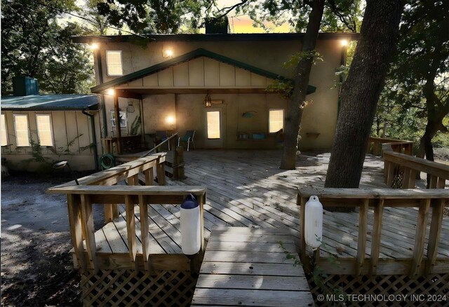 back house at dusk with a wooden deck