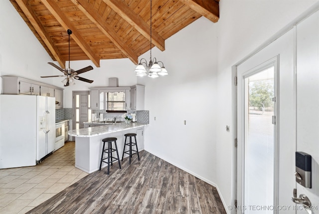 kitchen featuring kitchen peninsula, plenty of natural light, white appliances, and light hardwood / wood-style flooring