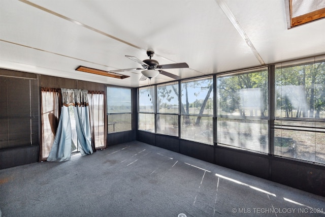 unfurnished sunroom featuring ceiling fan