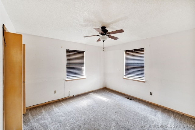 unfurnished room with ceiling fan, carpet, and a textured ceiling