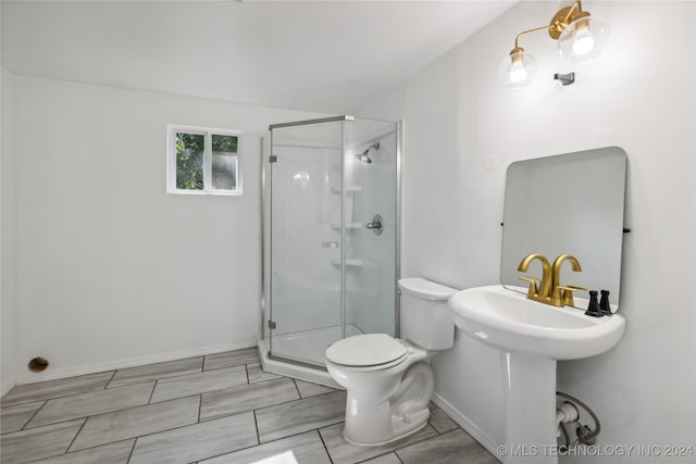 bathroom with a shower with door and toilet